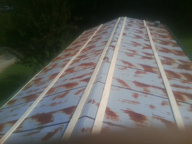 Rusted metal roof panels with new wood purlins before replacement — Storm Damage Roof Repair in Colona by Roofing Brothers