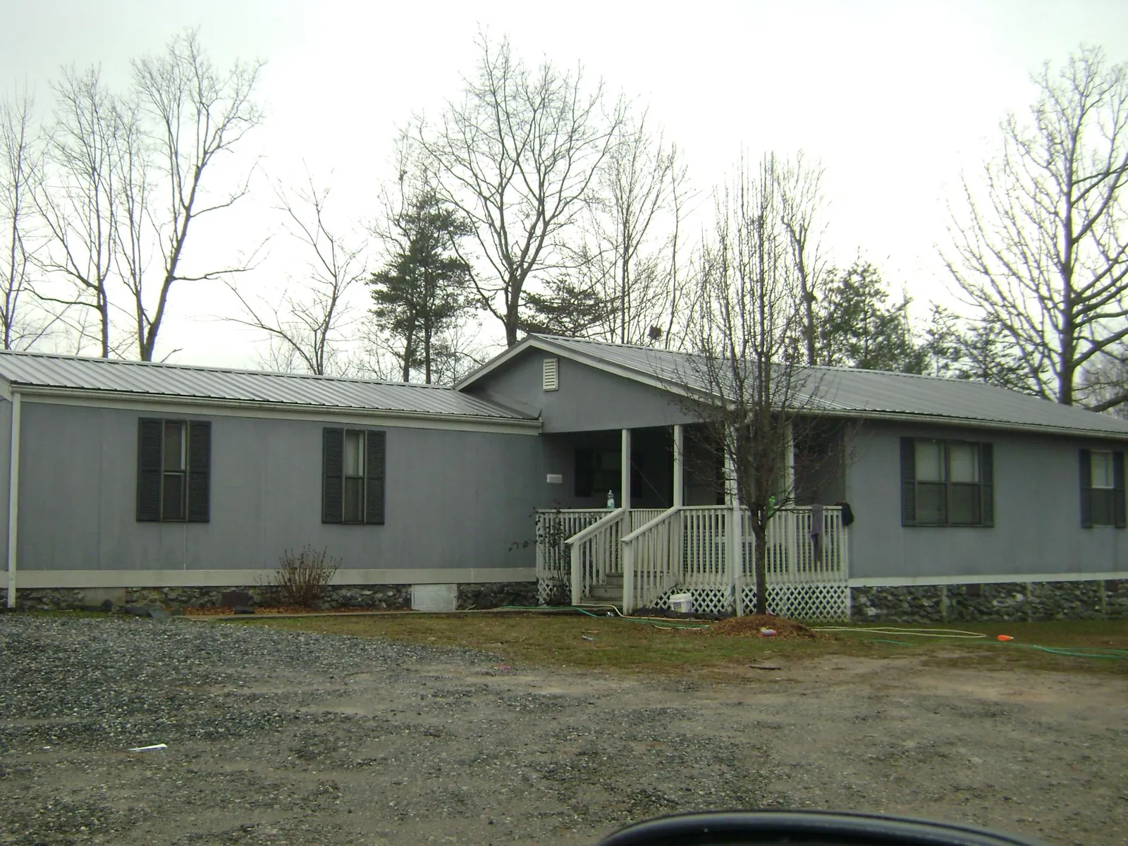 Metal roof over a manufactured home with a covered front porch in Colona